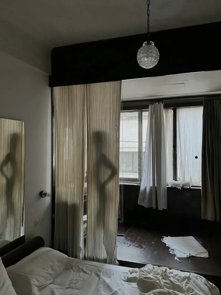 Intimate bedroom and bathroom interior with sheer curtains