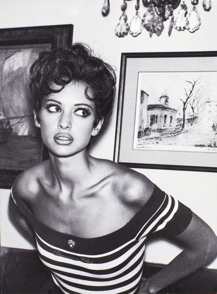 Black-and-white portrait of a woman with short curly hair in a striped top