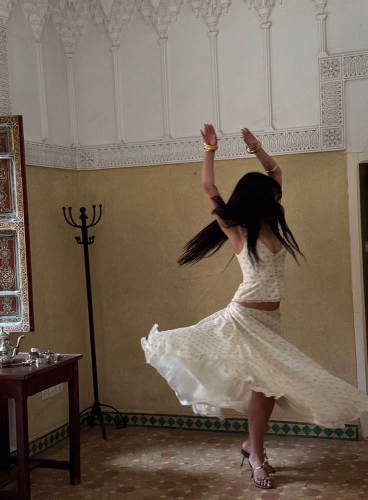 Woman in a white dress moving through an old European interior