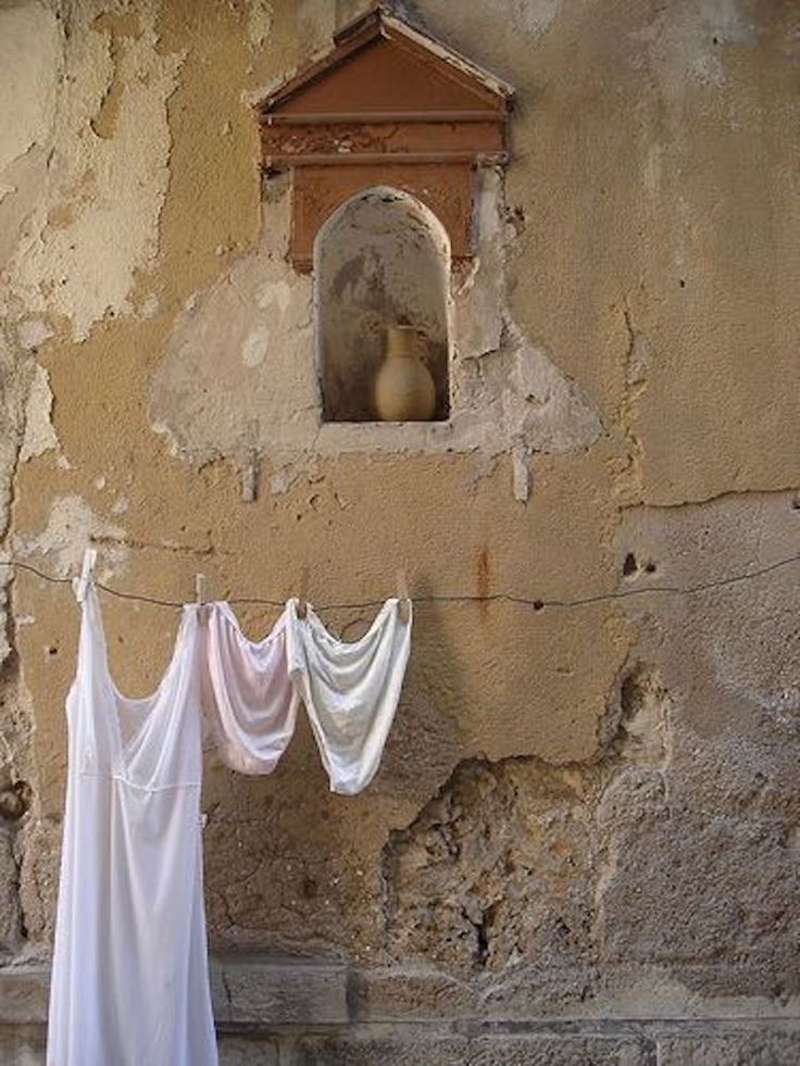 Linens drying on a line against a weathered European wall